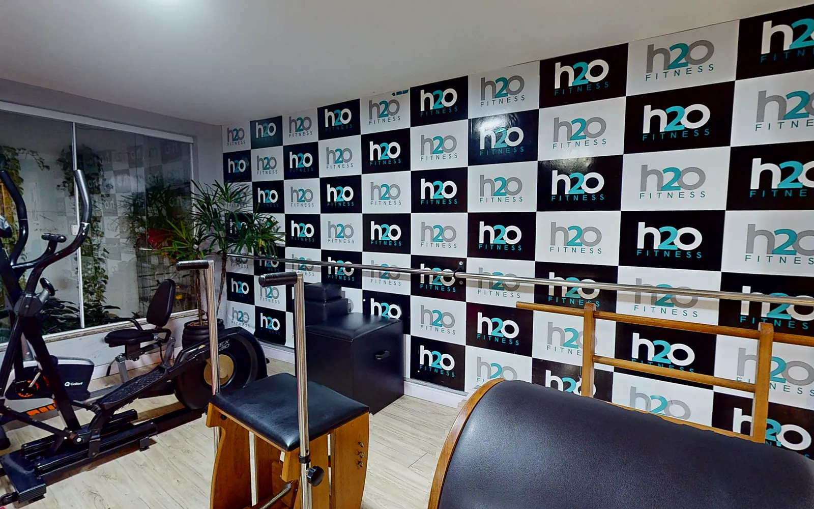 Aparelhos de pilates diante do painel com a marca H2O Fitness